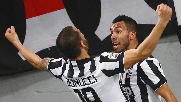 Fotbalisté Juventusu Carlos Tevez (vpravo) a Leonardo Bonucci aslaví gól proti AS Řím. Fotbalisté Juventusu Carlos Tevez (vpravo) a Leonardo Bonucci aslaví gól proti AS Řím.