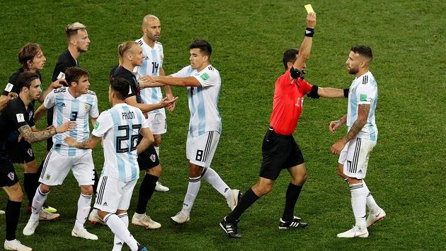 Argentinec Nicolas Otamendi dostává žlutou kartu za nakopnutí míče do Ivana Rakitiče. Argentinec Nicolas Otamendi dostává žlutou kartu za nakopnutí míče do Ivana Rakitiče.