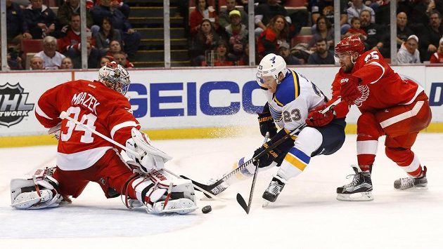 Dmitrij Jaškin (23) ze St. Louis překonává brankáře Detroitu Petra Mrázkka, vpravo Mike Green. Dmitrij Jaškin (23) ze St. Louis překonává brankáře Detroitu Petra Mrázkka, vpravo Mike Green.