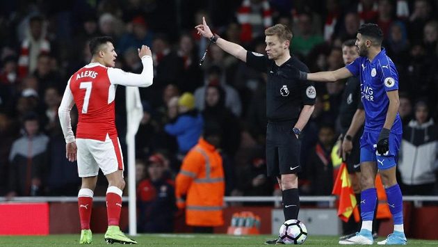 Rozhodčí Mike Jones vysvětluje útočníkovi Arsenalu, proč dostal žlutou kartu v duelu s Leicesterem. Alexis Sánchez se naopak snažil arbitra přesvědčit, že právě on byl obětí, když jej míč trefil do tváře. Rozhodčí Mike Jones vysvětluje útočníkovi Arsenalu, proč dostal žlutou kartu v duelu s Leicesterem. Alexis Sánchez se naopak snažil arbitra přesvědčit, že právě on byl obětí, když jej míč trefil do tváře.