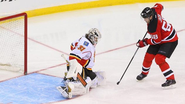 Brankář Calgary Karri Rämö likviduje šanci Ďáblů. Vpravo je útočník New Jersey Jaromír Jágr. Brankář Calgary Karri Rämö likviduje šanci Ďáblů. Vpravo je útočník New Jersey Jaromír Jágr.