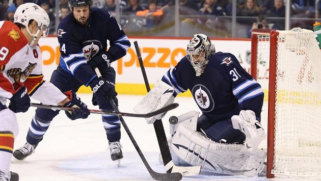 Brankář Winnipegu Pavelec zasahuje proti Upshallovi z Floridy. Brankář Winnipegu Pavelec zasahuje proti Upshallovi z Floridy.
