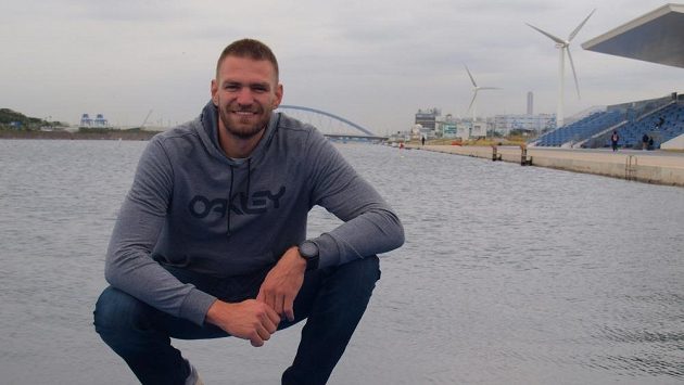 Skifař Ondřej Synek, za ním olympijský kanál v Tokiu i s větrnými turbínami. Skifař Ondřej Synek, za ním olympijský kanál v Tokiu i s větrnými turbínami.