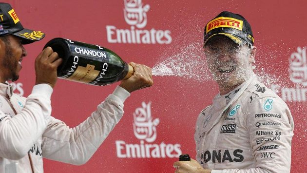 Lewis Hamilton "sprchuje" šampaňským svého týmového kolegu Nica Rosberga. Lewis Hamilton "sprchuje" šampaňským svého týmového kolegu Nica Rosberga.