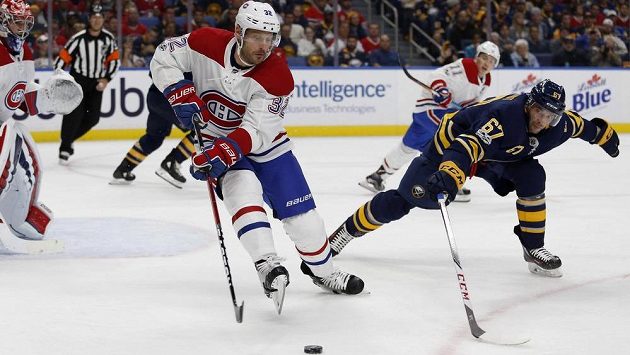 Mark Streit (32) z Montrealu a Benoit Pouliot (67) z Buffala. Mark Streit (32) z Montrealu a Benoit Pouliot (67) z Buffala.