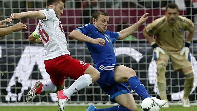 Řecký obránce Avraam Papadopulos (uprostřed) se snaží zastavit polského fotbalistu Jakuba Blaszczykowského Řecký obránce Avraam Papadopulos (uprostřed) se snaží zastavit polského fotbalistu Jakuba Blaszczykowského