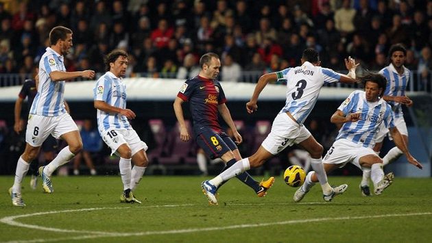 Fotbalisté Malagy v utkání proti Barceloně. Obránce Weligton (s číslem 3) se snaží společně se spoluhráči zastavit hostujícího záložníka Iniestu. Fotbalisté Malagy v utkání proti Barceloně. Obránce Weligton (s číslem 3) se snaží společně se spoluhráči zastavit hostujícího záložníka Iniestu.