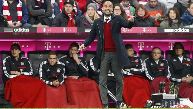 Trenér Bayernu Pep Guardiola v červeném puloveru při zápase se Schalke. Trenér Bayernu Pep Guardiola v červeném puloveru při zápase se Schalke.