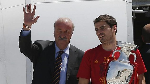 Trenér španělských fotbalistů Vicente del Bosque (vlevo) zdraví společně s kapitánem Ikerem Casillasem fanoušky na letišti v Madridu. Trenér španělských fotbalistů Vicente del Bosque (vlevo) zdraví společně s kapitánem Ikerem Casillasem fanoušky na letišti v Madridu.
