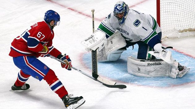 Gólman Vancouveru Roberto Luongo čelí nájezdu Maxe Paciorettyho z Montrealu. Gólman Vancouveru Roberto Luongo čelí nájezdu Maxe Paciorettyho z Montrealu.