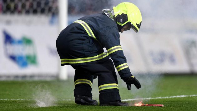 Hasič sbírá světlici na trávníku Doosan Areny během zápasu Plzně se Spartou. Hasič sbírá světlici na trávníku Doosan Areny během zápasu Plzně se Spartou.