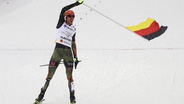 Finišman německé sdruženářské štafety Johannes Rydzek mává vlajkou v cíli. Finišman německé sdruženářské štafety Johannes Rydzek mává vlajkou v cíli.