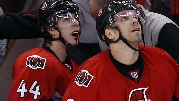 Zakrvácený střelec hattricku Jean-Gabriel Pageau (vlevo) sleduje na obří kostce opakování akce se spoluhráčem z Ottawy Milanem Michálkem. Zakrvácený střelec hattricku Jean-Gabriel Pageau (vlevo) sleduje na obří kostce opakování akce se spoluhráčem z Ottawy Milanem Michálkem.