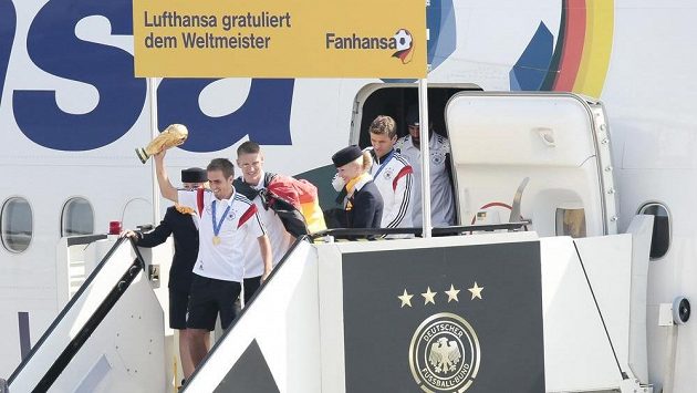 Kapitán Philipp Lahm s trofejí jako první opustil letadlo. Za ním Bastian Schweinsteiger. Kapitán Philipp Lahm s trofejí jako první opustil letadlo. Za ním Bastian Schweinsteiger.
