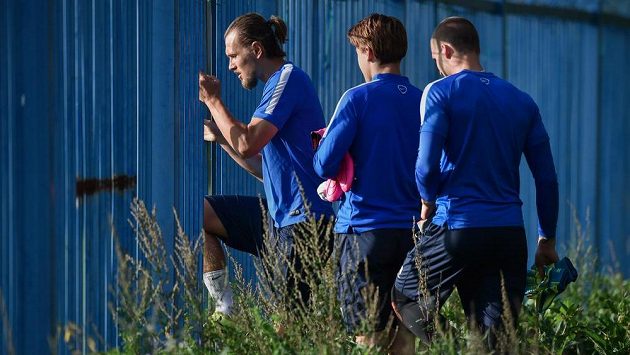 Liberecký obránce Ondřej Švejdík (vlevo) a jeho spoluhráči přichází dírou v plotě na trénikové hřiště před zápasem 1. kola základní skupiny EL proti Braze. Liberecký obránce Ondřej Švejdík (vlevo) a jeho spoluhráči přichází dírou v plotě na trénikové hřiště před zápasem 1. kola základní skupiny EL proti Braze.
