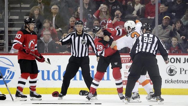 Travis Zajac z New Jersey Devils a český obránce Philadelphie Radko Gudas se do sebe pustili během utkání NHL. Bitku bedlivě sledují rozhodčí, fanoušci si rvačku natáčeli na mobilní telefony. Travis Zajac z New Jersey Devils a český obránce Philadelphie Radko Gudas se do sebe pustili během utkání NHL. Bitku bedlivě sledují rozhodčí, fanoušci si rvačku natáčeli na mobilní telefony.