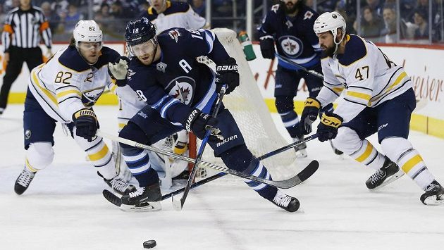 Zach Bogosian (47) a Nathan Beaulieu (82) z Buffala, mezi nimi Bryan Little (18) z Winnipegu. Zach Bogosian (47) a Nathan Beaulieu (82) z Buffala, mezi nimi Bryan Little (18) z Winnipegu.