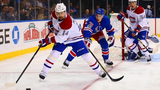 Český hokejový útočník Tomáš Plekanec se snaží přihrát puk v utkání s týmem New York Rangers v NHL. Zabránit mu chce v rozehrávce obránce Rangers Brady Skjei. Český hokejový útočník Tomáš Plekanec se snaží přihrát puk v utkání s týmem New York Rangers v NHL. Zabránit mu chce v rozehrávce obránce Rangers Brady Skjei.