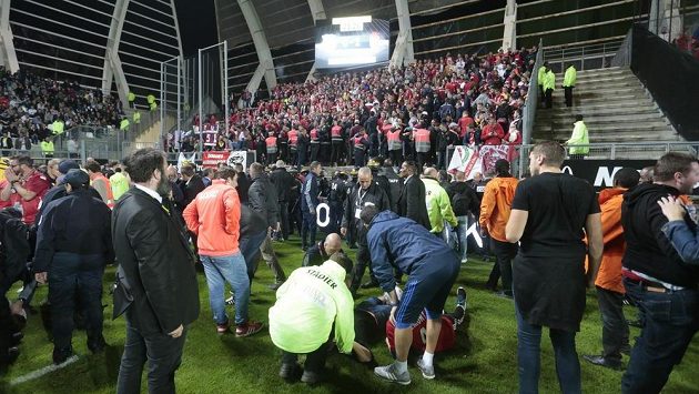 Pořadatelé v Amiens pomáhají zraněným fanouškům Lille. Pořadatelé v Amiens pomáhají zraněným fanouškům Lille.