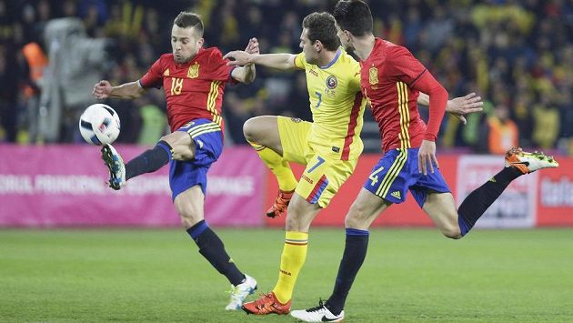 Španělští obránci Jordi Alba a Marc Bartra brání Adriana Popu z Rumunska. Španělští obránci Jordi Alba a Marc Bartra brání Adriana Popu z Rumunska.