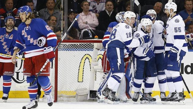 Centr Tampy Bay Lightning Tyler Johnson (vpravo uprostřed) přijímá gratulace od svých spoluhráčů, zatímco hráči NY Rangers odjíždí se sklopenou hlavou. Centr Tampy Bay Lightning Tyler Johnson (vpravo uprostřed) přijímá gratulace od svých spoluhráčů, zatímco hráči NY Rangers odjíždí se sklopenou hlavou.