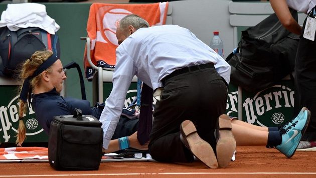 Běloruská tenistka Viktoria Azarenková je ošetřována v zápase prvního kola French Open s Italkou Karin Knappovou. Běloruská tenistka Viktoria Azarenková je ošetřována v zápase prvního kola French Open s Italkou Karin Knappovou.