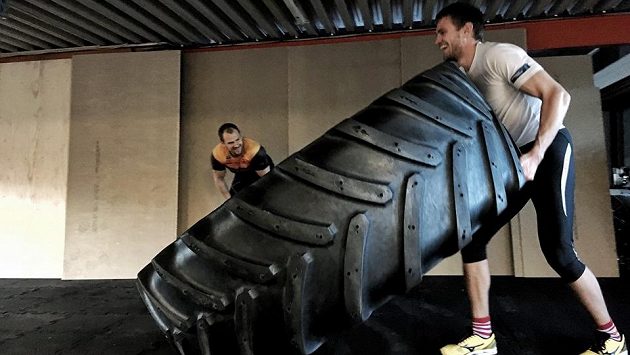 Ondřej Synek pod dohledem Olafa Tufteho obrací 280 kilogramů vážící pneumatiku. Ondřej Synek pod dohledem Olafa Tufteho obrací 280 kilogramů vážící pneumatiku.
