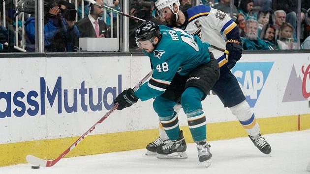 Tomáš Hertl ze San Jose Sharks vede puk podél mantinelu před obráncem St. Louis Blues Alexem Pietrangelem během pátého zápasu semifinálové série NHL. Tomáš Hertl ze San Jose Sharks vede puk podél mantinelu před obráncem St. Louis Blues Alexem Pietrangelem během pátého zápasu semifinálové série NHL.
