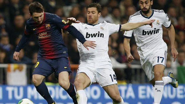 Unikajícího dirigenta Barcelony Lionela Messiho se snaží zastavit Xabi Alonso z Realu Madrid (uprostřed). Zcela vpravo je Álvaro Arbeloa. Unikajícího dirigenta Barcelony Lionela Messiho se snaží zastavit Xabi Alonso z Realu Madrid (uprostřed). Zcela vpravo je Álvaro Arbeloa.
