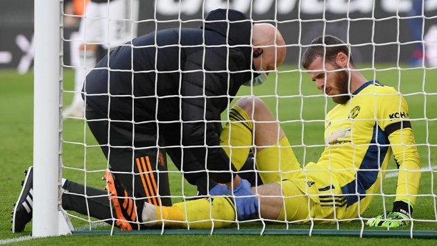 Lékař Manchesteru United se sklání nad zraněným brankářem Davidem de Geou. Lékař Manchesteru United se sklání nad zraněným brankářem Davidem de Geou.