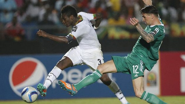 Asamoah Gyan z Ghany (vlevo) střílí gól přes alžírského obránce Carla Menjaniho. Asamoah Gyan z Ghany (vlevo) střílí gól přes alžírského obránce Carla Menjaniho.