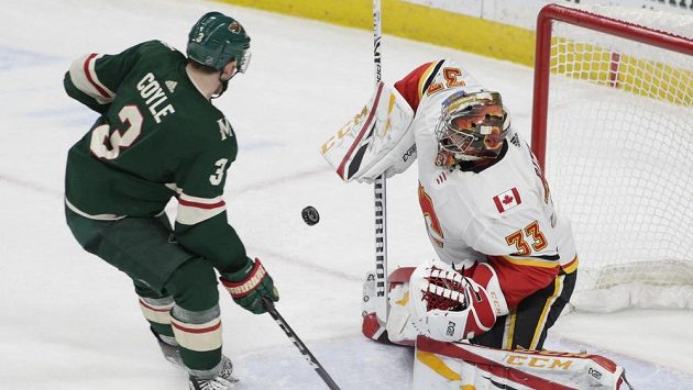 Charlie Coyle Z Minnesoty střílí na českého brankáře Davida Rittica z Calgary v utkání NHL. Charlie Coyle Z Minnesoty střílí na českého brankáře Davida Rittica z Calgary v utkání NHL.