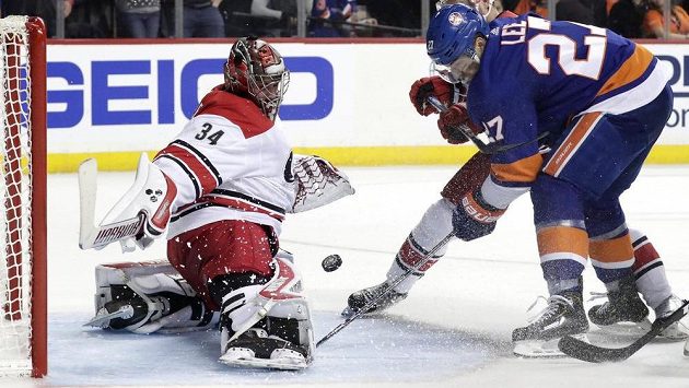 Český gólman Caroliny Petr Mrázek zasahuje proti Andersi Leemu (vlevo) v utkání 2. kola play off NHL proti NY Islanders. Český gólman Caroliny Petr Mrázek zasahuje proti Andersi Leemu (vlevo) v utkání 2. kola play off NHL proti NY Islanders.