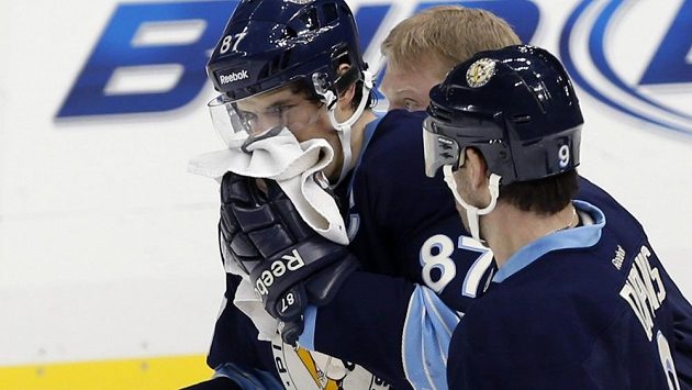 Zraněný Sidney Crosby opouští led poté, co byl zasažen pukem do obličeje. Zraněný Sidney Crosby opouští led poté, co byl zasažen pukem do obličeje.