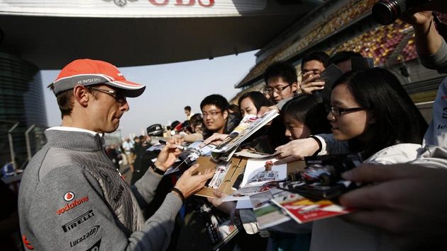 Pilot McLarenu Jenson Button se podepisuje fanouškům na okruhu v Šanghaji. Pilot McLarenu Jenson Button se podepisuje fanouškům na okruhu v Šanghaji.