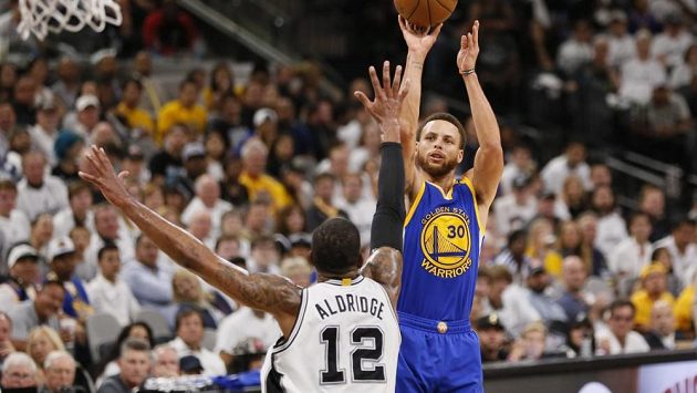 Hvězda Golden State Stephen Curry střílí přes LaMarcuse Aldridge ve třetím utkání finále Západní konference NBA. Hvězda Golden State Stephen Curry střílí přes LaMarcuse Aldridge ve třetím utkání finále Západní konference NBA.