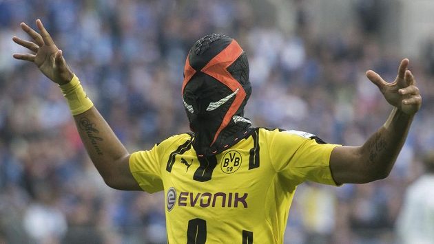Dortmundský střelec Pierre-Emerick Aubameyang a jeho oslava gólu v masce poté, co skóroval proti Schalke. Dortmundský střelec Pierre-Emerick Aubameyang a jeho oslava gólu v masce poté, co skóroval proti Schalke.