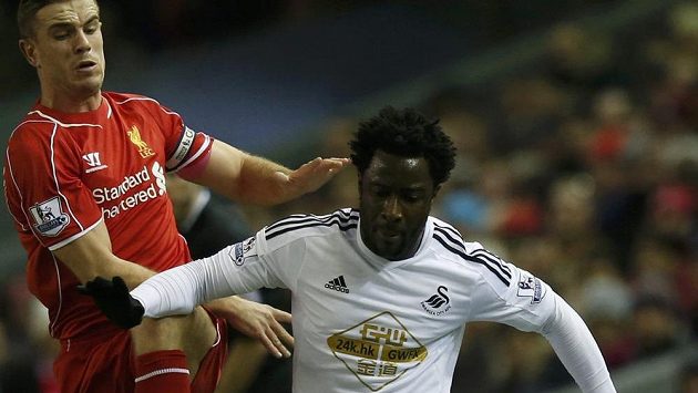 Bony Wilfried (vpravo) v dresu Swansea bojuje o míč v ligovém duelu s liverpoolským Jordanem Hendersonem. Bony Wilfried (vpravo) v dresu Swansea bojuje o míč v ligovém duelu s liverpoolským Jordanem Hendersonem.