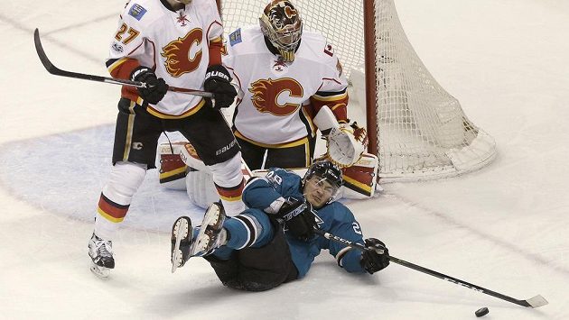 David Rittich v bráně Calgary pozoruje snahu Timo Meiera (28) ze San Jose. David Rittich v bráně Calgary pozoruje snahu Timo Meiera (28) ze San Jose.
