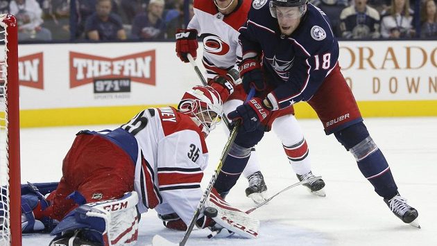 Brankář Caroliny Curtis McElhinney zasahuje proti Pierru-Lucovi Duboisovi v utkání NHL proti Columbusu. Brankář Caroliny Curtis McElhinney zasahuje proti Pierru-Lucovi Duboisovi v utkání NHL proti Columbusu.