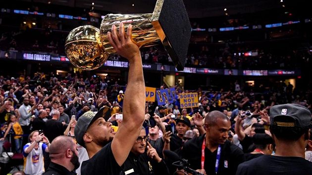 Stephen Curry drží nad hlavou Larry O'Brien Championship Trophy. Stephen Curry drží nad hlavou Larry O'Brien Championship Trophy.