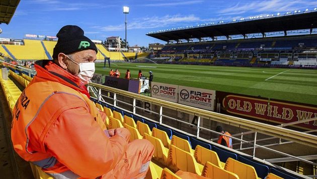Pořadatel s rouškou přes pusu sedí na stadionu v Parmě, kde se nakonec zápas domácích proti SPAL odehrálo. Pořadatel s rouškou přes pusu sedí na stadionu v Parmě, kde se nakonec zápas domácích proti SPAL odehrálo.