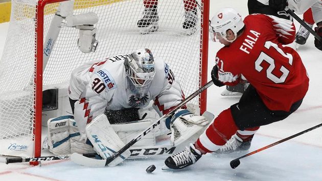 Švýcarský útočník Kevin Fiala doráží na rakouského brankáře Davida Kickerta. Švýcarský útočník Kevin Fiala doráží na rakouského brankáře Davida Kickerta.