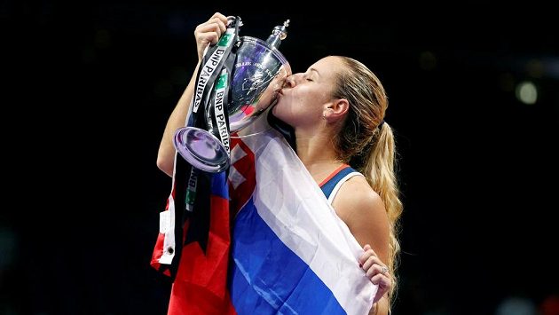 Štastná Dominika Cibulková zabalena do vlajky Slovenska líbá trofej. Štastná Dominika Cibulková zabalena do vlajky Slovenska líbá trofej.