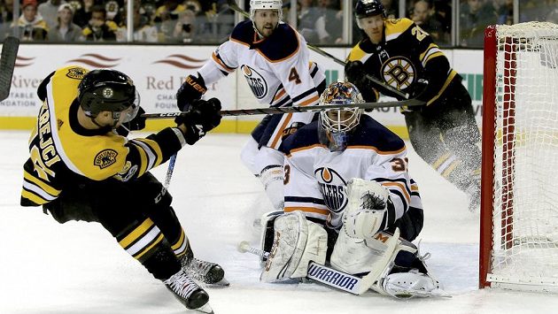 Bostonský David Krejčí (46) a gólman Edmontonu Cam Talbot (33). Bostonský David Krejčí (46) a gólman Edmontonu Cam Talbot (33).