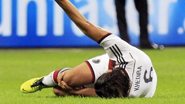 Německý fotbalista Sami Khedira se po svém zranění v přátelském utkání s Itálií svíjí na trávníku. Německý fotbalista Sami Khedira se po svém zranění v přátelském utkání s Itálií svíjí na trávníku.