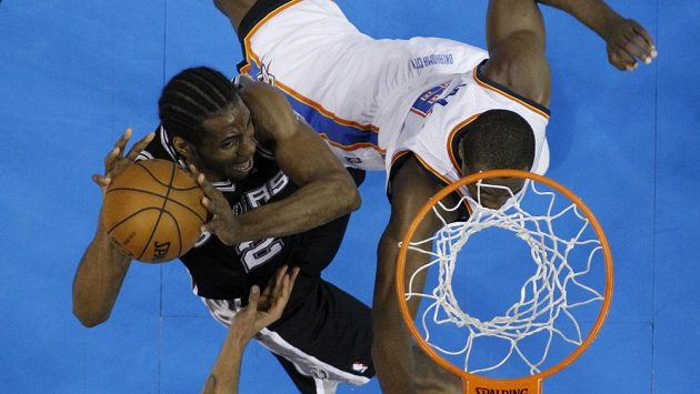 Kawhi Leonard ze San Antonia Spurs střílí koš před bránícím Sergem Ibakou z Oklahoma City Thunders. Kawhi Leonard ze San Antonia Spurs střílí koš před bránícím Sergem Ibakou z Oklahoma City Thunders.