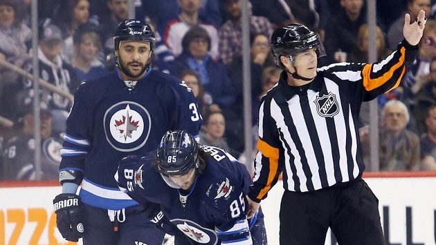 Mathieu Perreault (85) z Winnipegu po zranění během zápasu s Edmontonem. Mathieu Perreault (85) z Winnipegu po zranění během zápasu s Edmontonem.