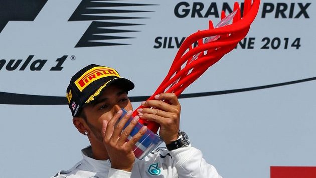 Lewis Hamilton a červené cosi na stupních vítězů v Silverstonu v roce 2014. Lewis Hamilton a červené cosi na stupních vítězů v Silverstonu v roce 2014.