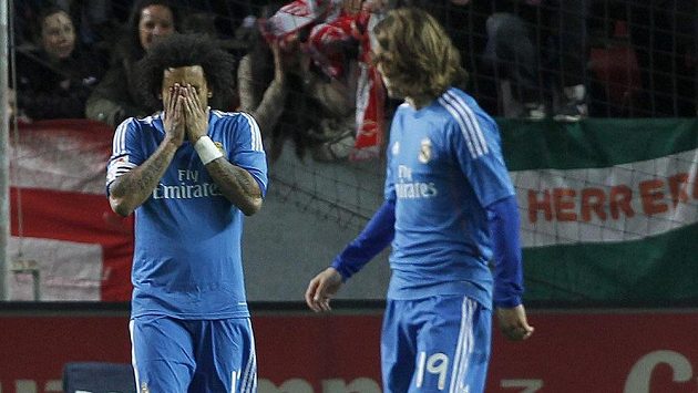 Zklamaný obránce Realu Madrid Marcelo Vieira (vlevo) na hřišti FC Sevilla. Vpravo přihlíží záložník Luka Modrič. Zklamaný obránce Realu Madrid Marcelo Vieira (vlevo) na hřišti FC Sevilla. Vpravo přihlíží záložník Luka Modrič.